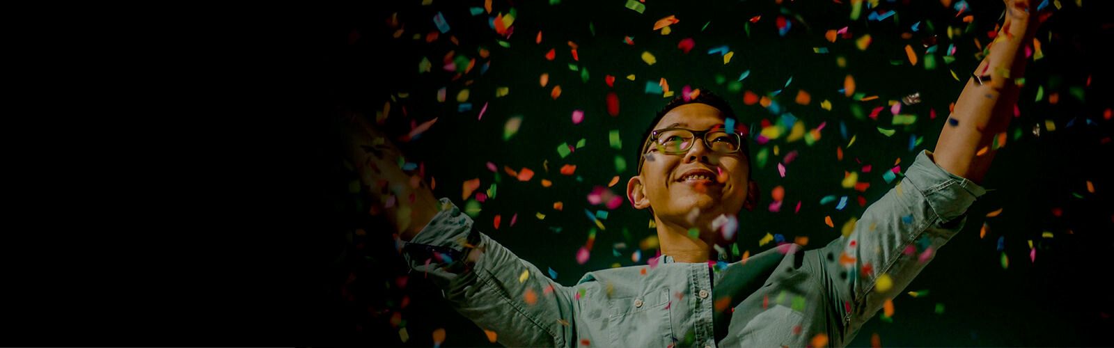 A man standing with floating confetti paper.