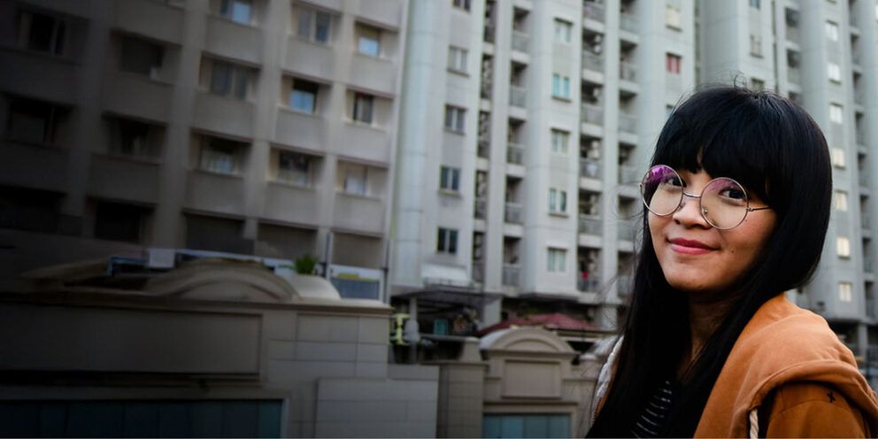 Female standing in front of a building.